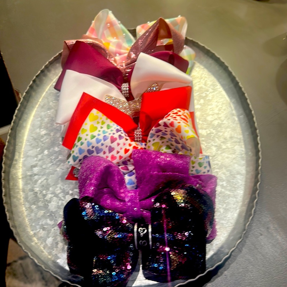 Eight JoJo Siwa bows. Various colors.